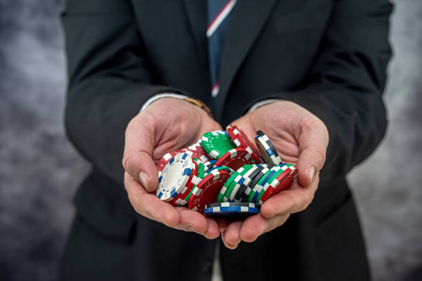 Man in suit holding poker chips playing in the casino. Gambling concept